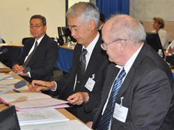 Kaname Ikeda looks on as Council Chair Evgeny Velikhov presents professor Osamu Motojima with his ITER contract. (Click to view larger version...)